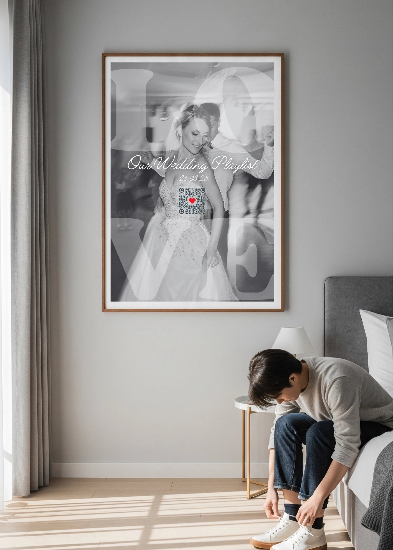 Person adjusting shoes in a bedroom with a framed photograph on the wall.