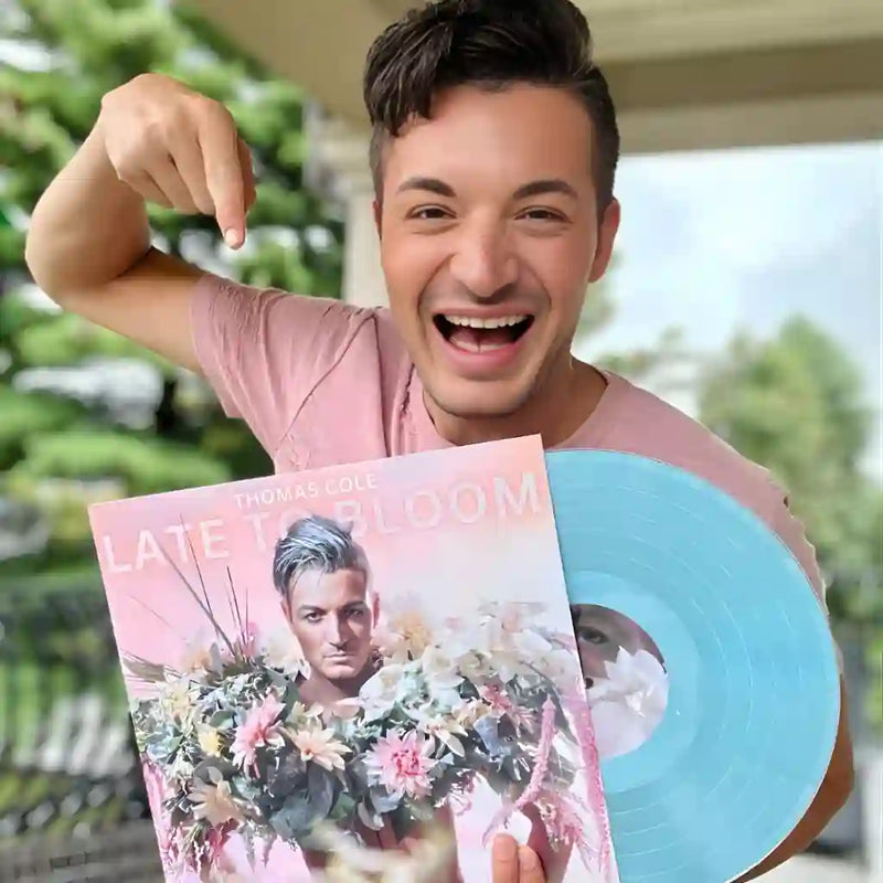 An excited customer holding their sky blue custom vinyl record and matching photo jacket, showing the high-quality finish of a bespoke artist project.