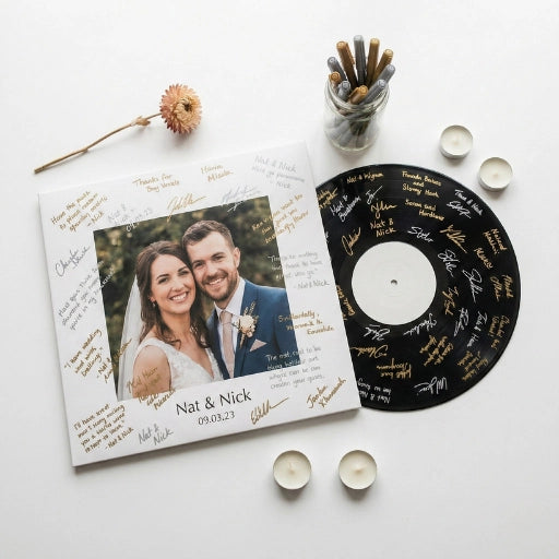 Interactive wedding guest book signature station with a personalized vinyl record jacket signed by guests using metallic markers.