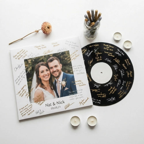Interactive wedding guest book signature station with a personalized vinyl record jacket signed by guests using metallic markers.
