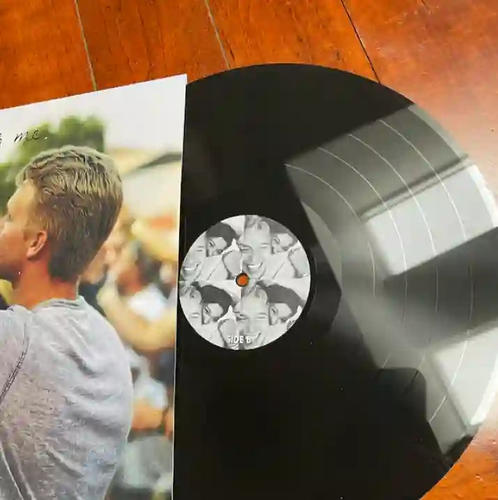 Close-up of a 12-inch vinyl record showing the high-resolution print quality of a personalized photo grid center label.