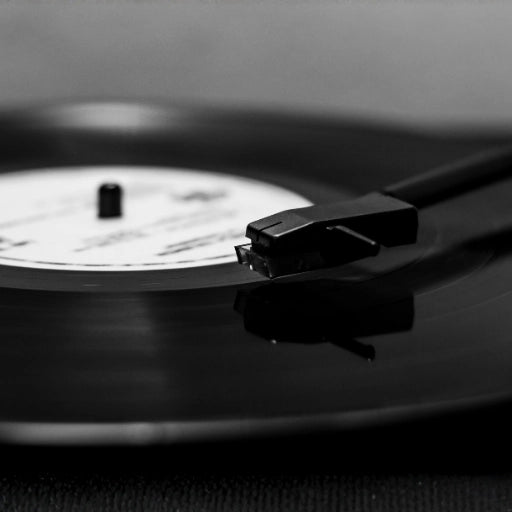 Close-up of a turntable needle on a black vinyl record representing professional mastering for wedding audio guestbook messages.