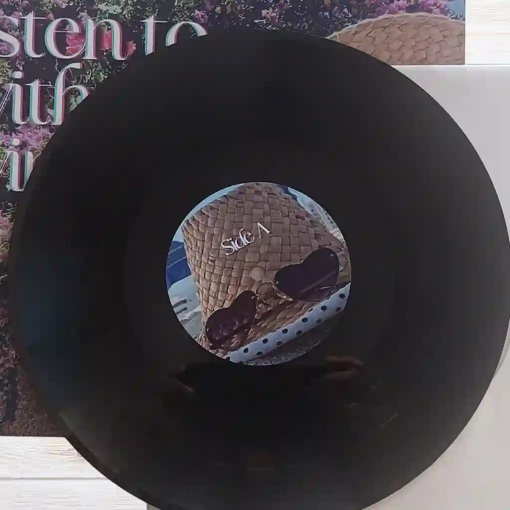 Custom center label stickers on a black vinyl record showing personalized text and photos for a bespoke, one-off vinyl record gift.