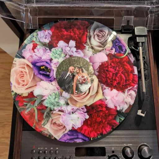 A vibrant floral picture disc vinyl record playing on a turntable, representing a creative wedding keepsake.