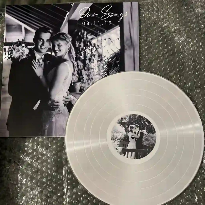 A silver custom vinyl record featuring a black and white wedding photo on the jacket; a concrete example of a personalized anniversary gift.
