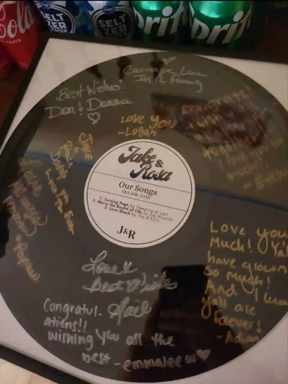 Detailed view of a mixtape vinyl record with a personalized label for "Jake & Rosa," signed with heartfelt messages as a lifelong keepsake.